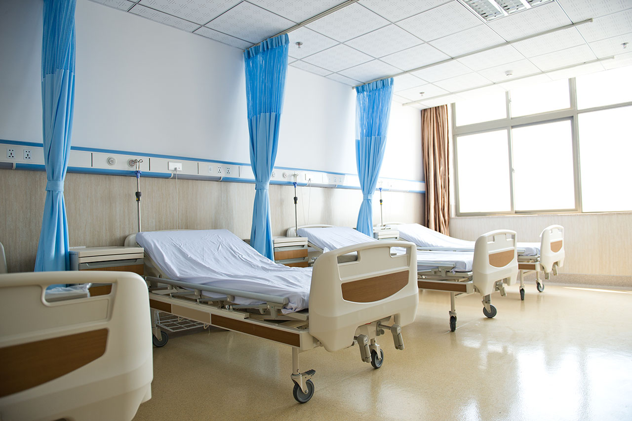 A row of empty beds in a hospital ward