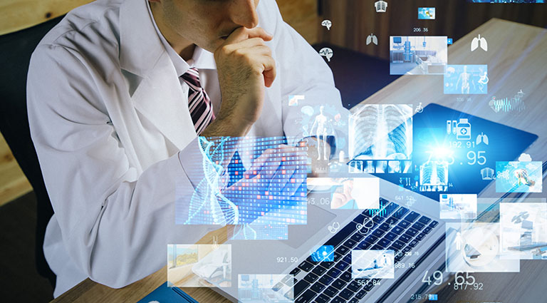 Male interventional cardiologist researching on his laptop