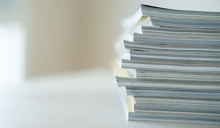 Several medical journals stacked on a table